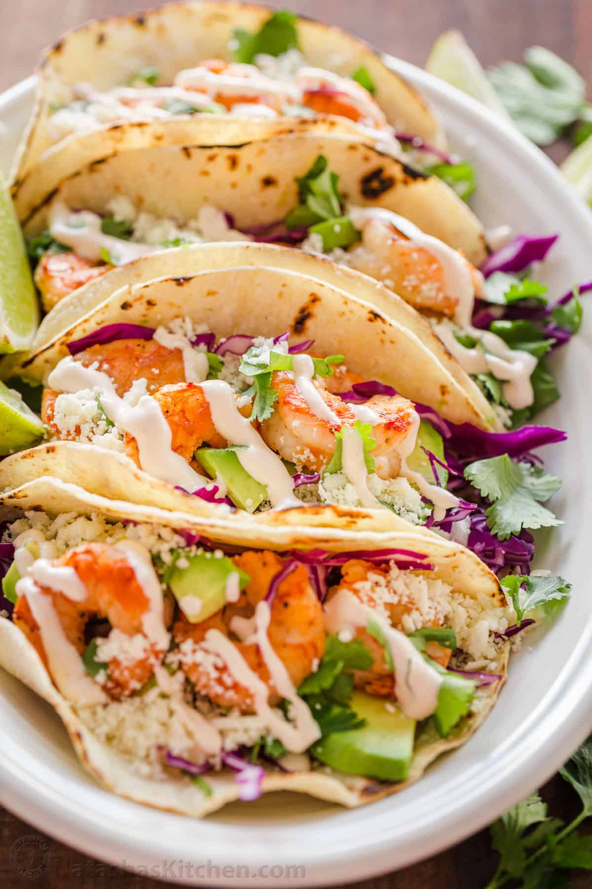 easy Shrimp tacos on a platter drizzled with garlic-lime crema shrimp taco sauce