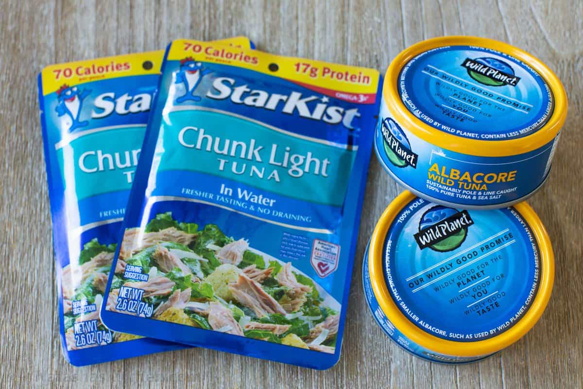 This Classic Tuna Salad recipe is light and fresh, made with tuna, celery, eggs, and the best tuna salad dressing. Great for meal prep lunch! Two packets of StarKist chunk light in water next to two cans of Wild Planet canned fish.